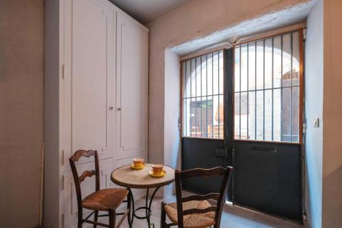 Cette chambre dispose d'une petite table et de chaises. dans l'établissement Charming studio In the heart of Cannes, à Cannes