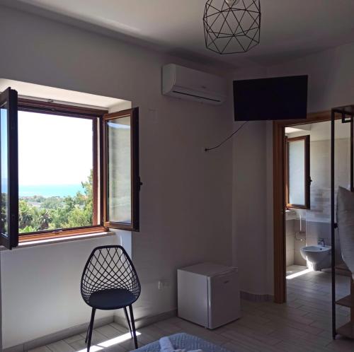 a living room with a chair and a window at Le Muse in Falerna Marina