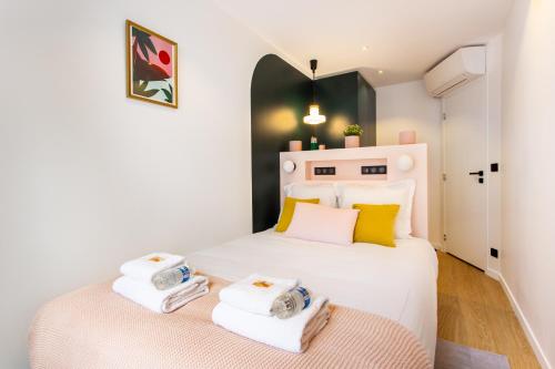 - une chambre avec un lit blanc et 2 serviettes dans l'établissement Magnificent apartment - 3BR-6P - Nation, à Paris