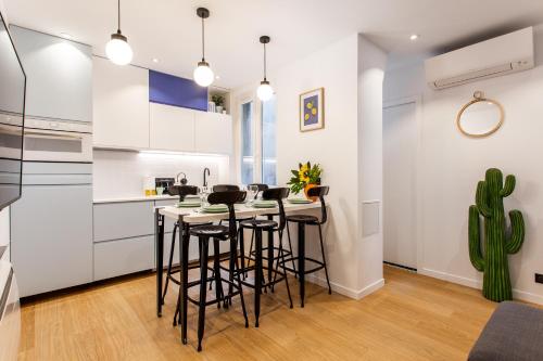 une cuisine avec des armoires blanches et des tabourets de bar dans l'établissement Magnificent apartment - 3BR-6P - Nation, à Paris