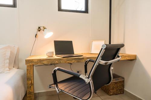 a desk with a laptop and a chair next to a bed at Grand Villa with Private Patio & Parking by Tasman in San José del Cabo