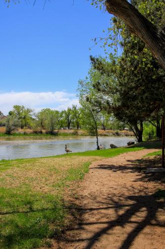 a person walking along a path next to a river at Riverwood Resort on the Gunnison in Delta