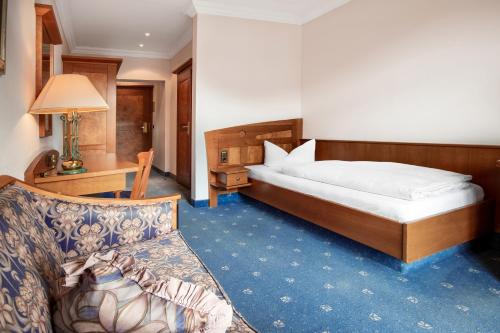 a hotel room with a bed and a couch at Post-Hotel in Mittenwald