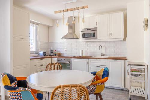 - une cuisine avec une table et des chaises blanches dans l'établissement Exceptional spacious one bedroom flat in Cannes, à Cannes