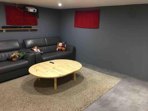 a living room with a black couch and a wooden coffee table at Magnifique maison spa in Aix-en-Ergny