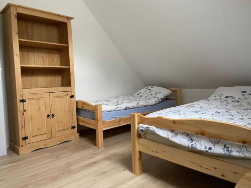 two beds and a cabinet in a room at Magnifique maison spa in Aix-en-Ergny