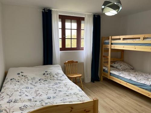 a bedroom with two bunk beds and a window at Magnifique maison spa in Aix-en-Ergny