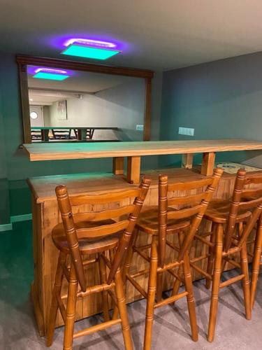a bar with wooden chairs and a counter top at Magnifique maison spa in Aix-en-Ergny