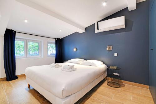 une chambre avec un grand lit blanc avec des murs bleus dans l'établissement Welcoming apartment -1BD-4P - 18th arrd, à Paris