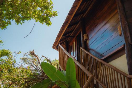 a wooden house with a balcony and trees at Hurricane Jeri in Jericoacoara