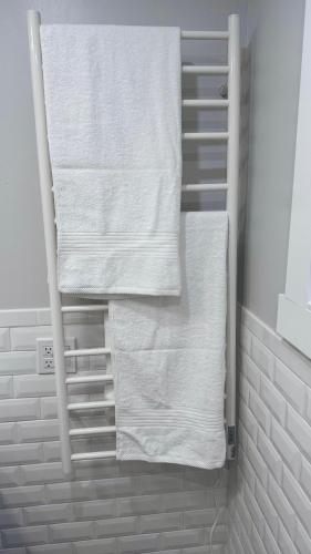 a towel rack with white towels in a bathroom at Modern and Cozy Pine Hills Home from Early 1900s in Albany