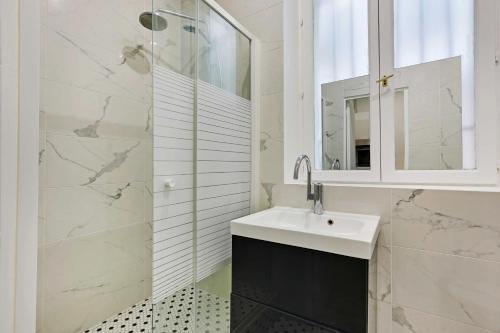 une salle de bain blanche avec un lavabo et une douche dans l'établissement Cosy studio for 2P - République-Marais, à Paris