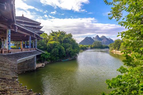 桂林市にあるGuilin Peach Blossom Bay Hotelの建物と山を背景にした川