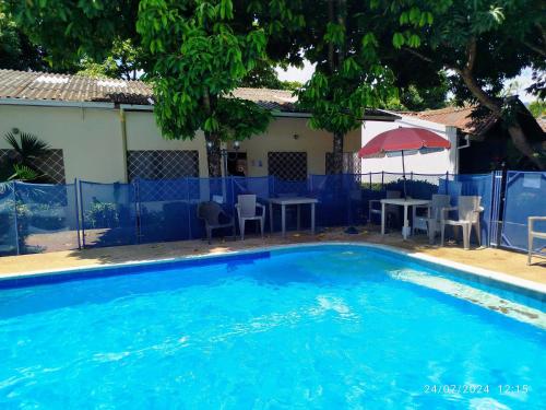 Una gran piscina azul con sillas y mesas. en Condominio El Portal Casa 5, en Carmen de Apicalá