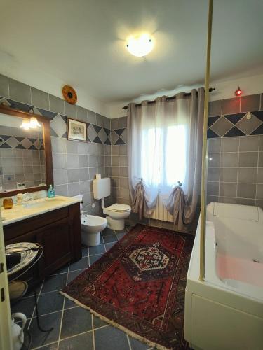 a bathroom with a toilet and a sink and a tub at Casa del sole in Rivarotta