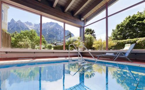 a swimming pool with a view of mountains at Post-Hotel in Mittenwald
