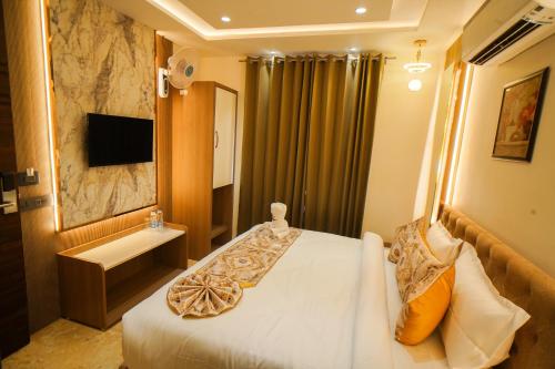 a hotel room with a bed and a sink at Hotel Ammison Inn & Suites in Amritsar