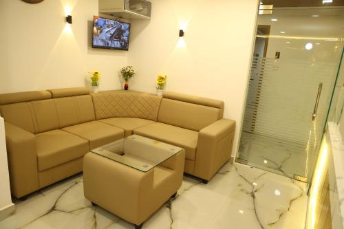 a living room with a couch and a tv at Grand Tamim Hotel in Mangalore
