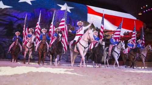 a group of people on horses holding american flags at Mountain Palace by Eden Crest in Gatlinburg