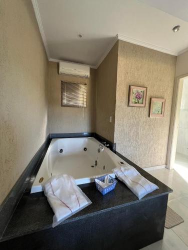 a bathroom with a bath tub with two towels at Hotel Fazenda Santa Maria in Serra Negra
