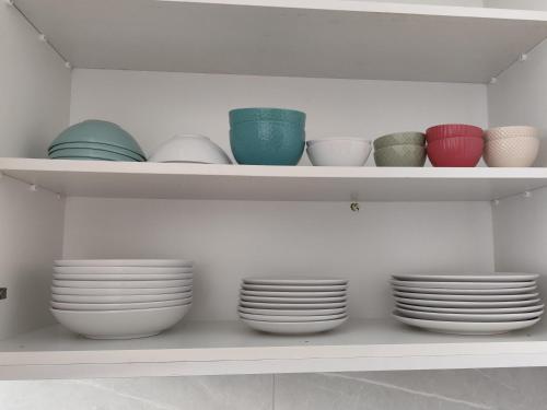 a white shelf with plates and bowls on it at Marina view seaside apartment in Larnaka