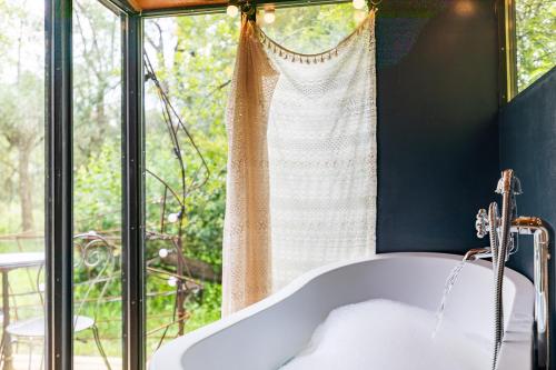 a bath tub in a bathroom with a window at Les Cabanes Des Marais in La Madelaine-sous-Montreuil