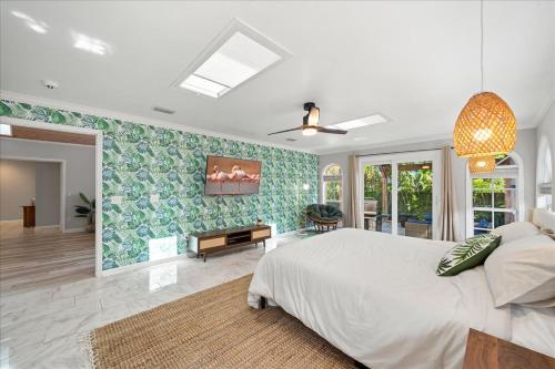 una camera da letto con un letto grande e un soggiorno di 5B - Modern Pool - Game Room - Beachside - 7 Bed - Mural- AC - Washer Dryer a Indian Harbour Beach