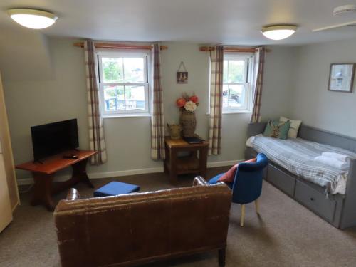 a living room with a bed and a couch at The Riverside in Lechlade