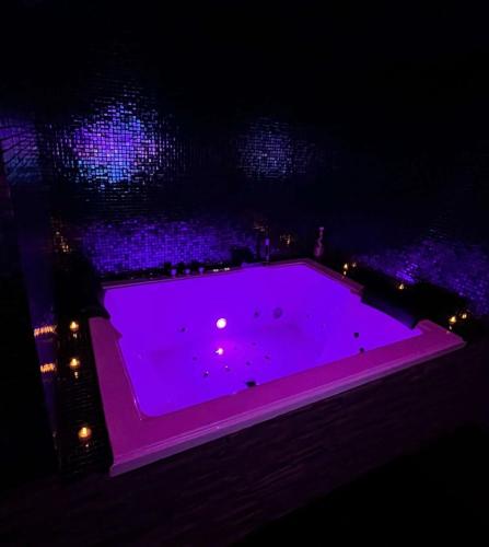 a purple hot tub with lights in the water at night at Le Pink in Aubervilliers
