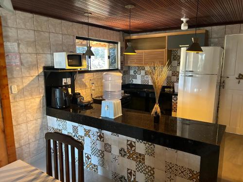 a kitchen with a refrigerator and a microwave at Casa no centro da cidade com garagem. in Itacaré