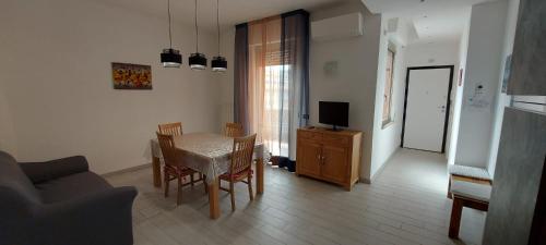 a living room with a table and chairs and a television at Casamia in Follonica