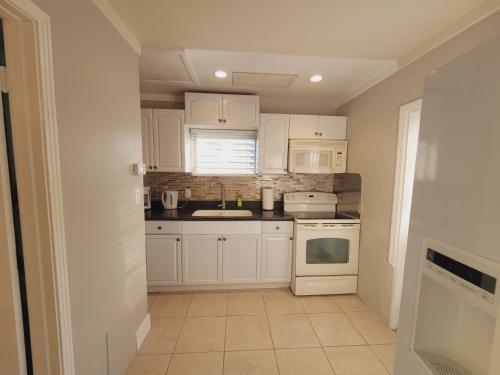 a kitchen with white cabinets and a sink at Cottage on Walking Distance To Nokomis Beach in Nokomis