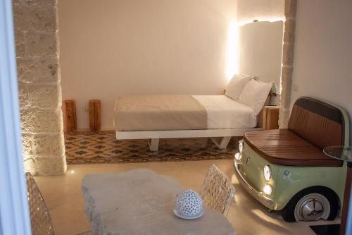 a room with a bed and a table with a small car at G home in Fasano