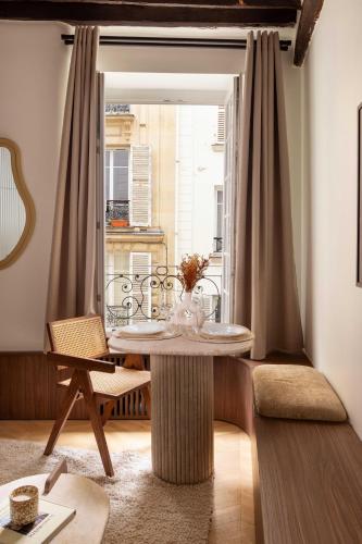 une salle à manger avec une table et une fenêtre dans l'établissement Luxurious A-C flat - 2P - Bastille-Le Marais, à Paris