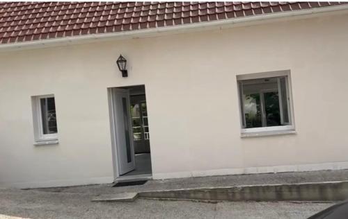a white building with a door and two windows at Luxury holiday home in Beautiful France in Godenvillers