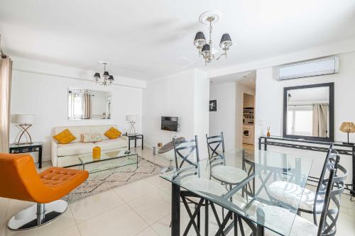 un salon avec une table en verre et des chaises dans l'établissement Cosy 2-Bedroom apartment - close to Martinez Hotel, à Cannes