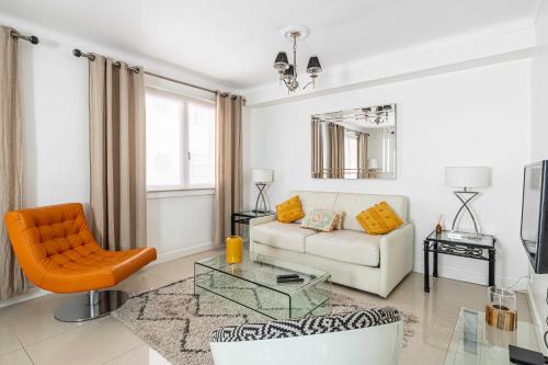 - un salon avec un canapé blanc et une chaise orange dans l'établissement Cosy 2-Bedroom apartment - close to Martinez Hotel, à Cannes