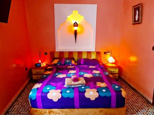 a bedroom with a large bed with a colorful comforter at Maison d'hôtes Cité Portugaise in El Jadida