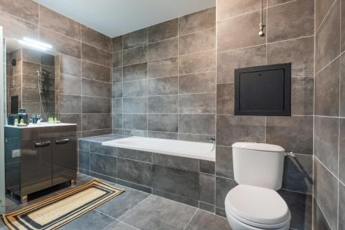 La salle de bains est pourvue de toilettes et d'une télévision murale. dans l'établissement Flat with Garden - 1BR-4P - Montreuil, à Montreuil