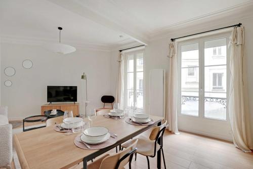 une salle à manger avec une table avec des chaises et une télévision dans l'établissement Authentic apartment - 3BR-8P - Clignancourt, à Paris
