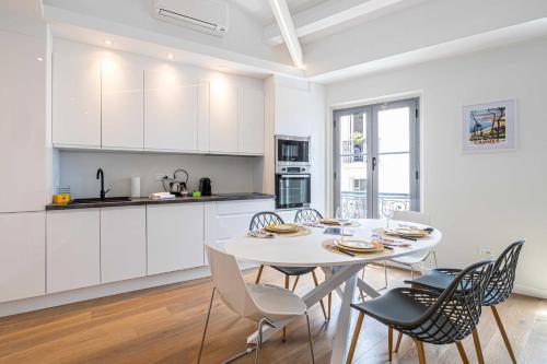 une cuisine et une salle à manger avec une table et des chaises blanches dans l'établissement Charming apartment - Near the Old Port and Suquet, à Cannes