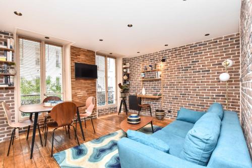 - un salon avec un canapé bleu et un mur en briques dans l'établissement Magnificent apartment- 2BR-6P - Republique, à Paris