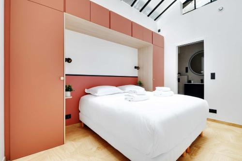 une chambre avec un grand lit blanc avec des murs orange dans l'établissement Elegant apartment - 3BR-7P - Moulin Rouge, à Paris