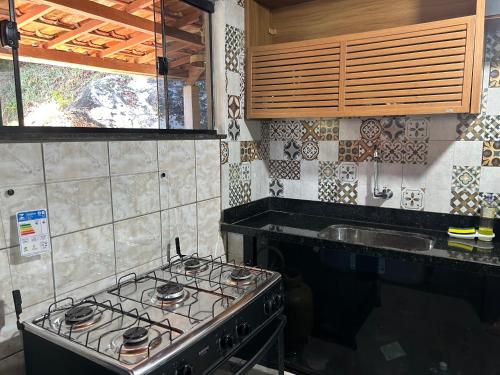 a kitchen with a stove and a sink at Casa no centro da cidade com garagem. in Itacaré