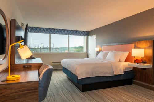 a hotel room with a bed and a large window at Hampton Inn Manchester Downtown in Manchester