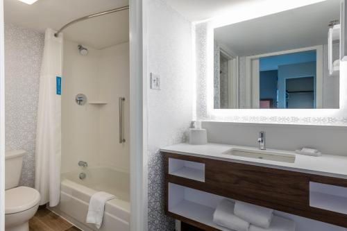 a bathroom with a sink and a toilet and a mirror at Hampton Inn Manchester Downtown in Manchester