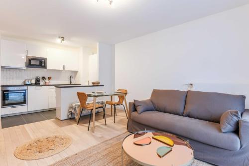 un salon avec un canapé et une table dans l'établissement Classy appartement - Flea Market, à Saint-Ouen