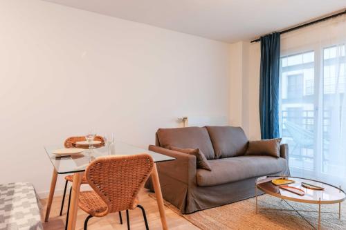 un salon avec un canapé et une table dans l'établissement Classy appartement - Flea Market, à Saint-Ouen