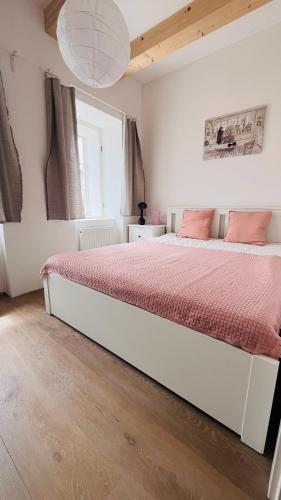 a bedroom with a large bed with pink sheets at Četnická Stanice Mšeno in Mšeno
