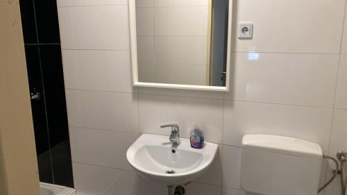 a bathroom with a sink and a toilet and a mirror at Villa Minden City in Minden